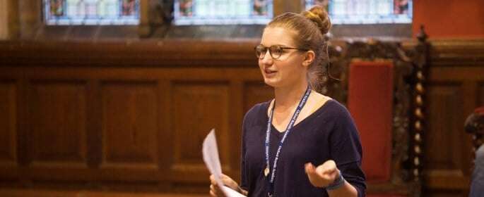 Image shows a student speaking to an audience at the Oxford Union. 