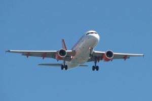 Image shows an EasyJet plane in flight. 