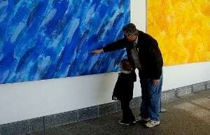 Image shows a small child being led around an art gallery.