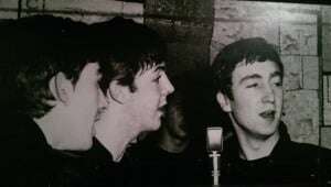 Image shows a black and white photograph of the Beatles.
