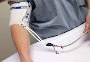 Image shows someone having their blood pressure taken with a disposable cuff.