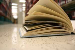 Image shows a book lying open on a library floor.