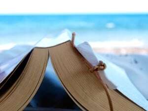 Image shows an open book on a beach.