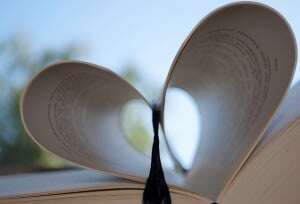 Image shows a book with its pages forming the shape of a heart.