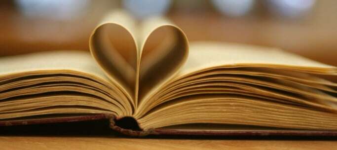 Image shows a book with some of its pages folded into a heart.
