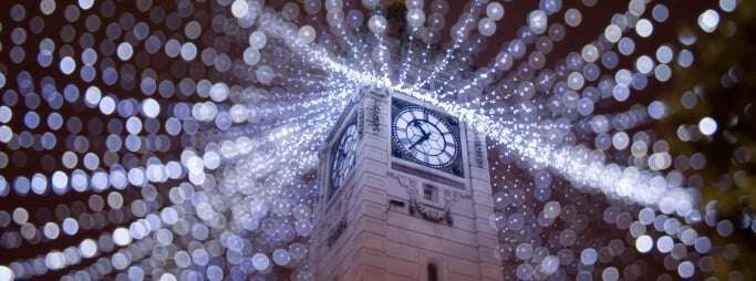 Image shows a clock tower in Brighton with fairy lights strung from it in all directions.