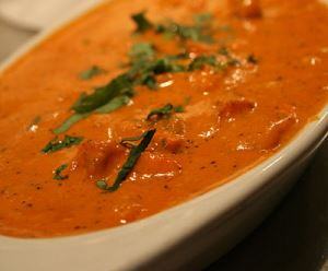 Image shows a serving dish full of chicken tikki masala.