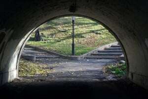 Image shows a path under a bridge, which forks into two possible directions.