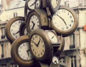 Image shows a sculpture in Paris made of dozens of clocks.