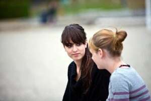 Image shows two young women having a conversation.