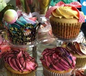 Image shows a stand filled with multicoloured cupcakes.