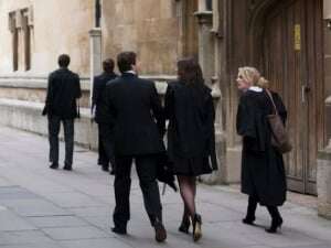 Image shows Oxford students in sub fusc, deep in discussion, walking down Turl Street.