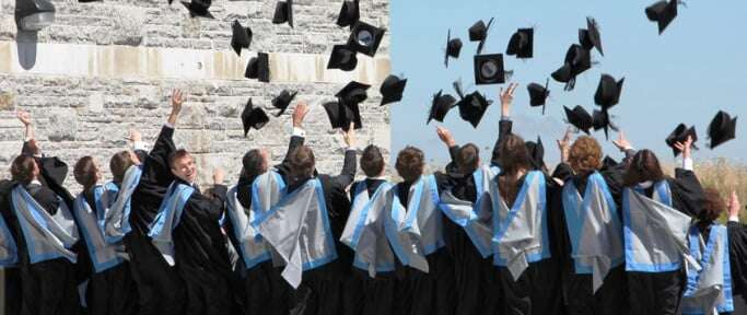 Image shows graduates at the University of Exeter flinging their mortarboards into the air.