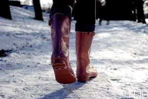 Image shows someone walking in red wellies on snow.