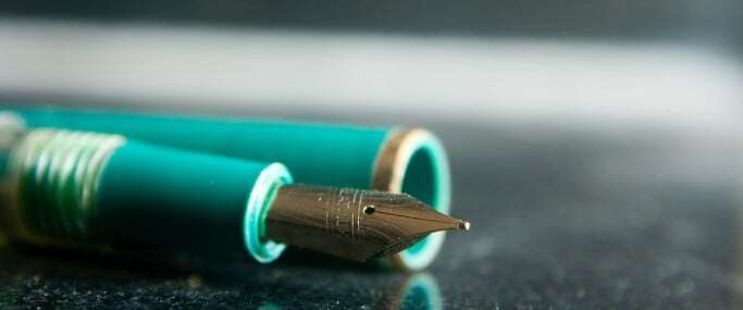Image shows a turquoise fountain pen with the lid off.