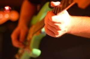 Image shows someone playing an electric guitar.