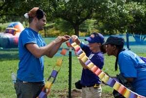 Image shows three people putting up a paper chain.