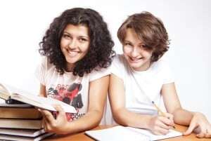 Image shows two smiling students in what is very obviously a posed stock photo.
