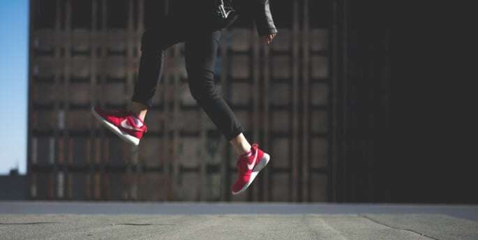 Image shows someone in red shoes jumping for joy.