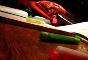 Image shows pens and paper on a desk.