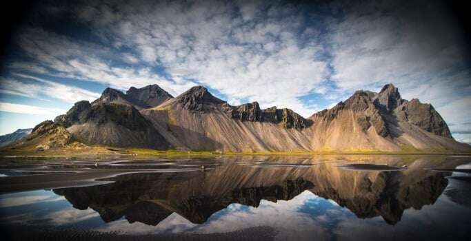 Image shows a dramatic mountain range in Iceland.