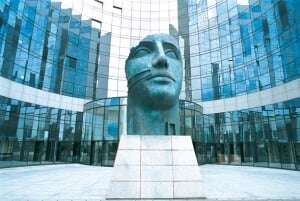 Image shows KPMG's Paris offices, with a statue of a face in the courtyard.
