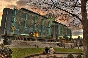 Image shows two students sitting outside a university library.