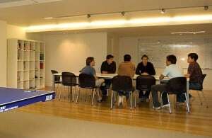 Image shows a meeting talking place in an office. 