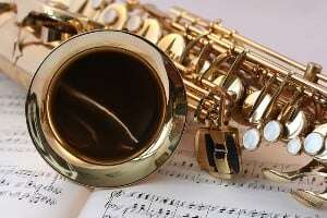 Image shows a saxophone lying on some sheet music.