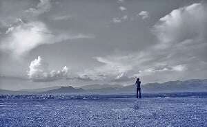 Image shows a photographer taking a photo of some mountains.