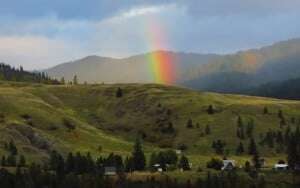Image shows a rainbow against mountains.