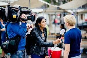 Image shows a reporter interviewing someone.