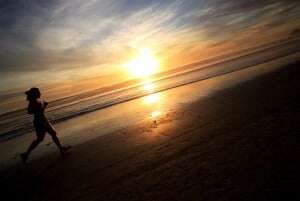 Image shows a young woman running at dawn. 