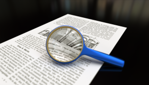 Image shows a piece of paper under a magnifying glass. 