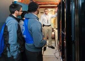 Image shows an employee of the US Department of Agriculture showing students around a facility.