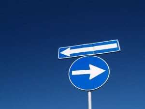 Image shows two road signs, pointing in opposite directions.