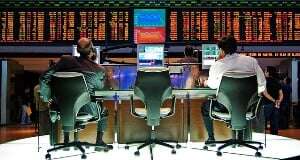 Image shows two workers at a stock exchange.