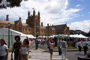Image shows students milling around at the University of Sydney's Orientation Week, with its beautiful buildings in the background.