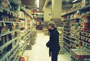 Image shows a woman browsing in a supermarket.