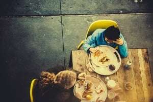 Image shows a parent and a child having lunch together.