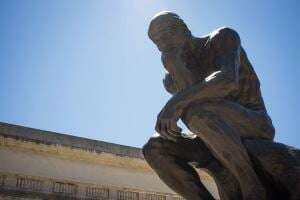 Image shows Rodin's The Thinker.