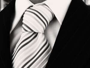 Image shows a close-up of a tie worn with a smart shirt and jacket.