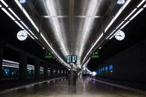 Image shows a train station platform with two clocks.