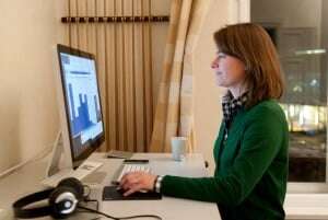 Image shows a woman at a desk using Trello software on her computer.