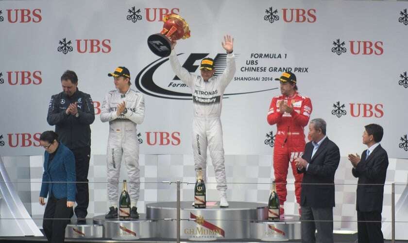 Image shows Lewis Hamilton on the podium.