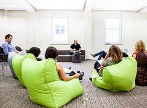 Image shows people sitting around on comfy chairs in deep discussion.