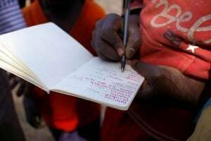 Image shows someone writing down vocabulary in a notebook.
