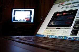 Image shows a laptop on YouTube with a projector alongside it.