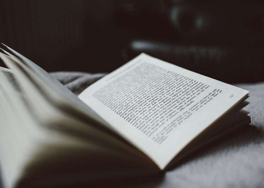 A book lies open on a bed. 