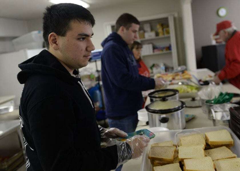 A young man volunteers in a soup kitchen. 